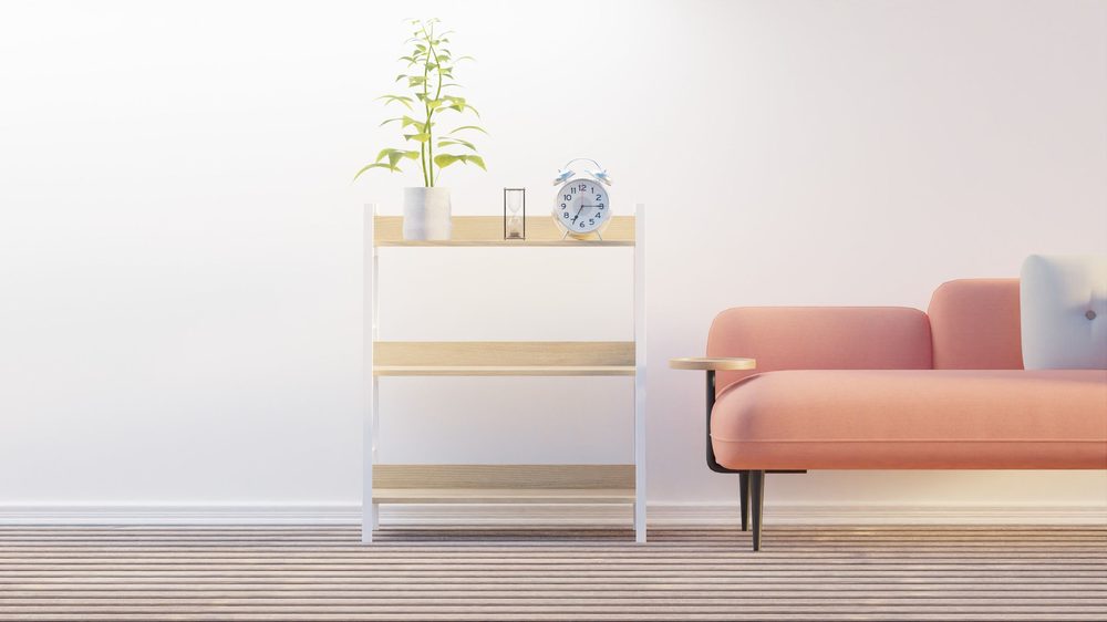 Minimal living room with a blush sofa, slim shelf and calm neutral wall