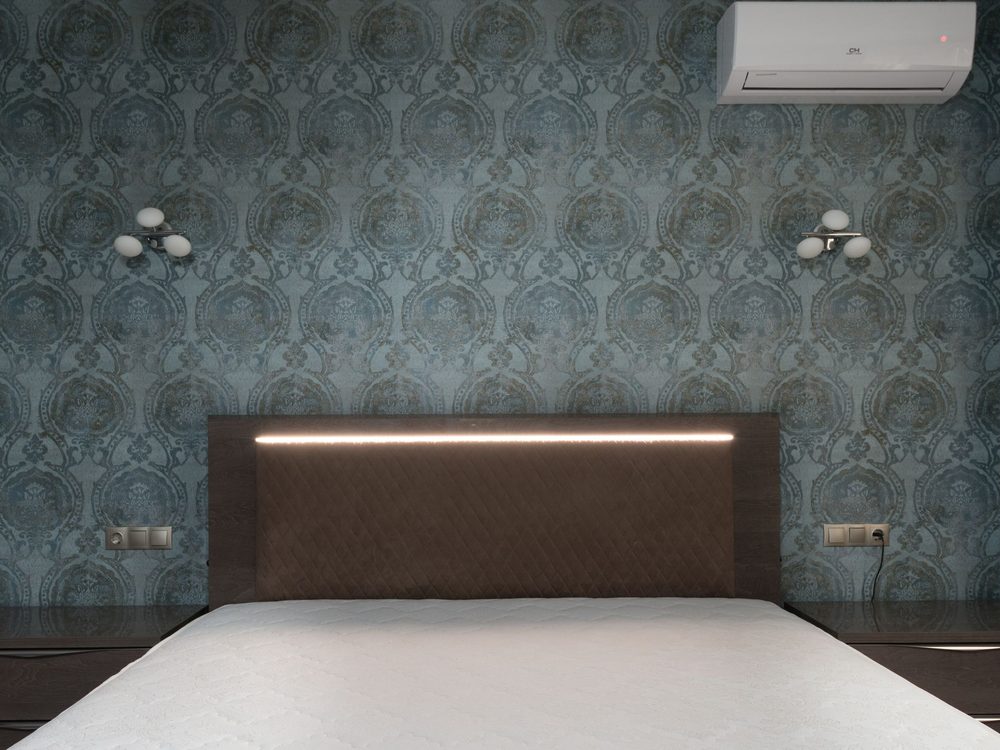 Bedroom with a deep teal ornamental damask feature wall behind the bed