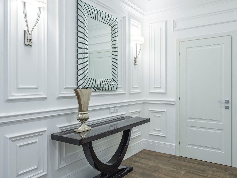 Clean, minimalist hallway with smooth prepared white walls, a console and mirror